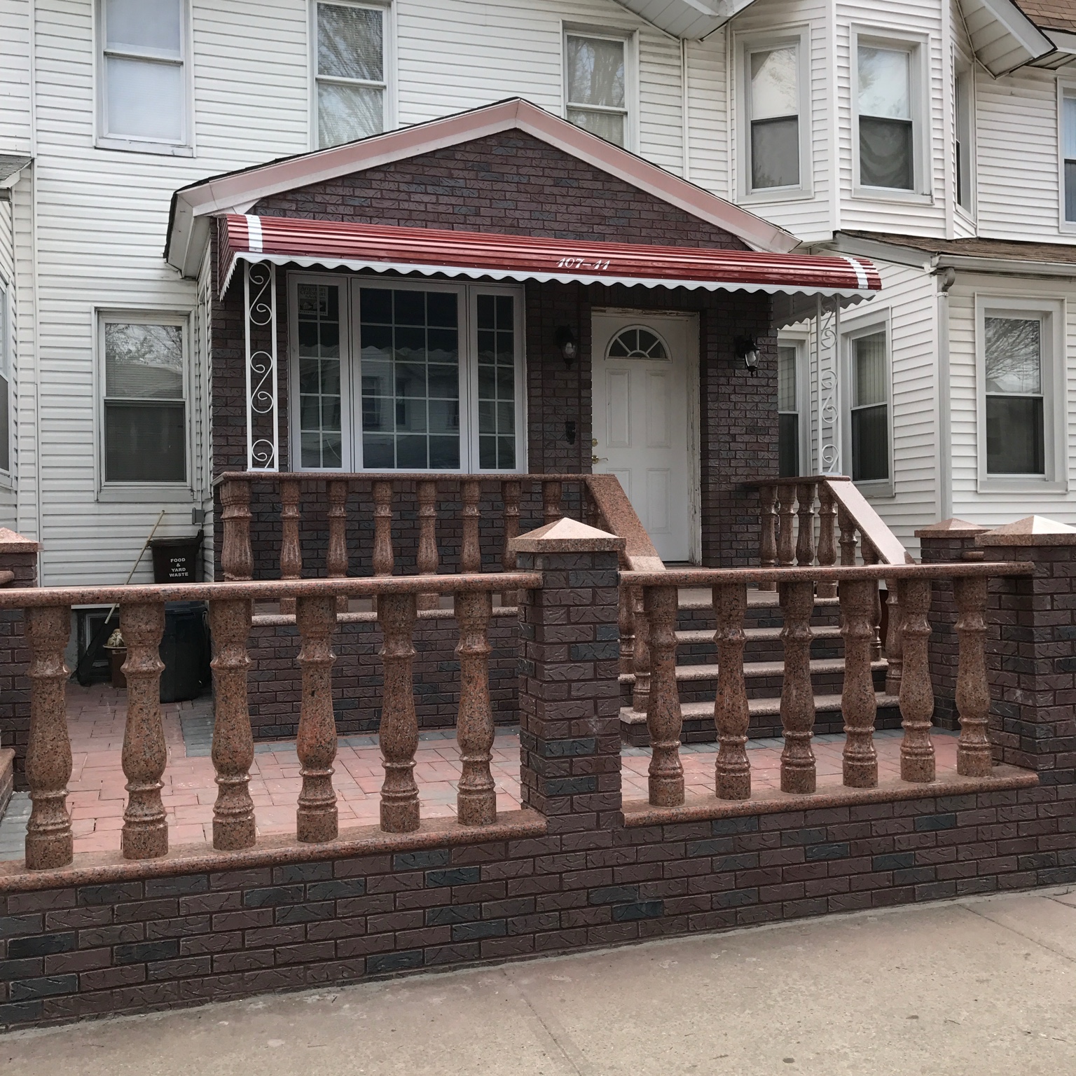 Residential porch with red awning over front entry